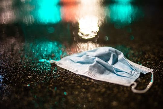 Ein Mund-Nasenschutz liegt im Regen auf der Strasse (Symbolfoto): Am Freitag enden in Berlin die meisten Corona-Beschränkungen.