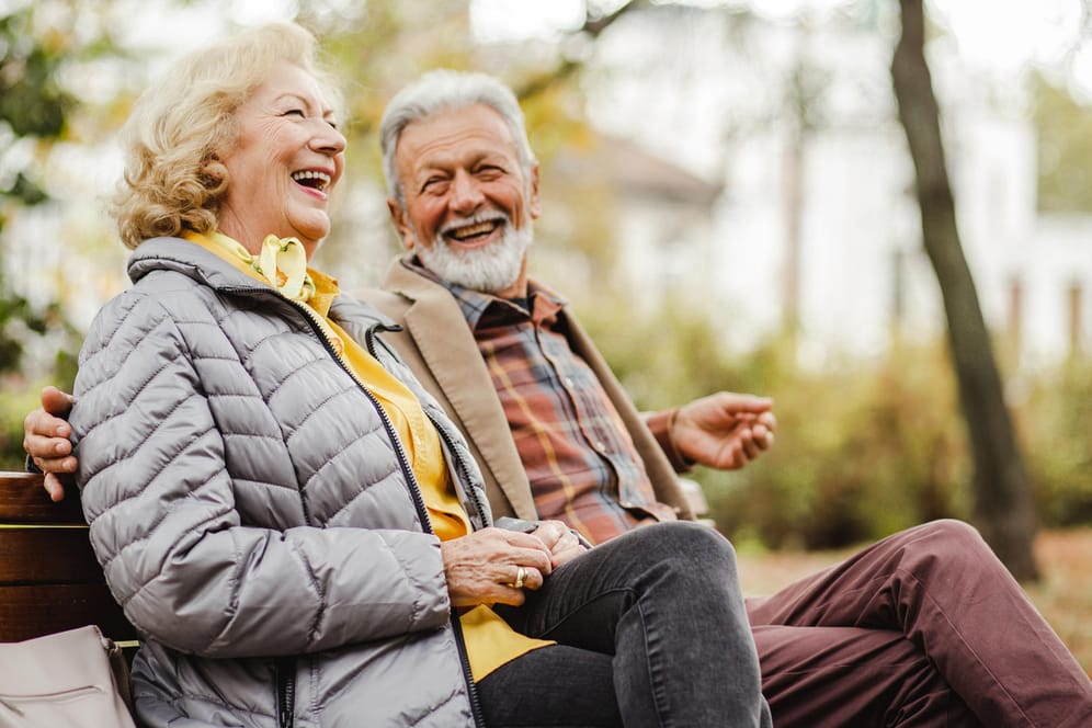 Glückliches älteres Paar auf einer Bank (Symbolbild): Je mehr Rentenpunkte Sie sammeln, desto üppiger fällt Ihre Rente aus.