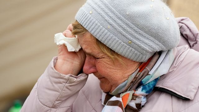 Eine Frau namens Swetlana, die aus Charkiw angereist ist, weint, während sie mit anderen Kriegsflüchtlingen aus der benachbarten Ukraine am polnischen Grenzübergang in Medyka in einer Schlange wartet.