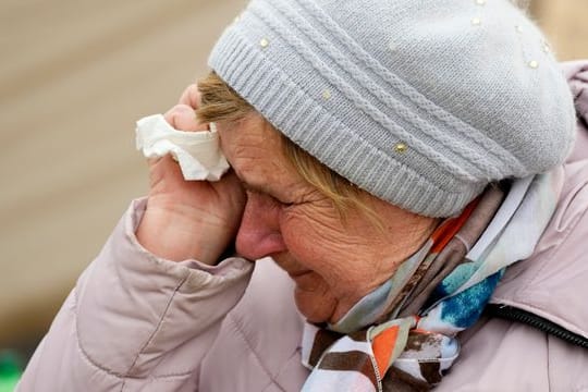 Eine Frau namens Swetlana, die aus Charkiw angereist ist, weint, während sie mit anderen Kriegsflüchtlingen aus der benachbarten Ukraine am polnischen Grenzübergang in Medyka in einer Schlange wartet.