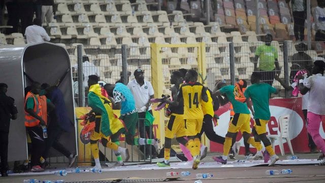 Ghanas Spieler rennen bringen sich nach dem Spiel in Abuja in Sicherheit.