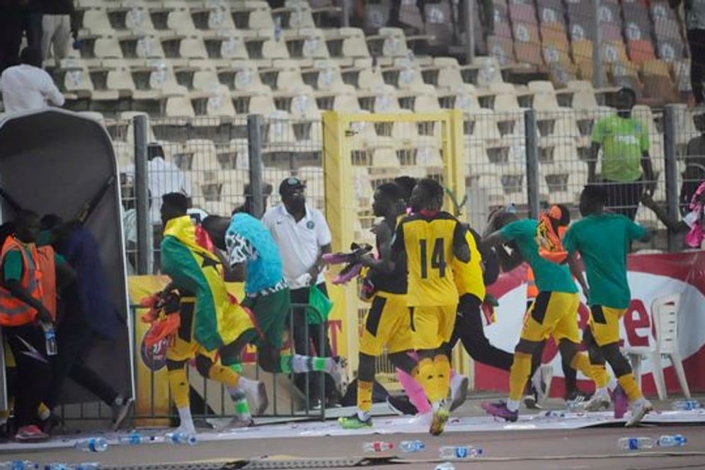 Ghanas Spieler rennen bringen sich nach dem Spiel in Abuja in Sicherheit.