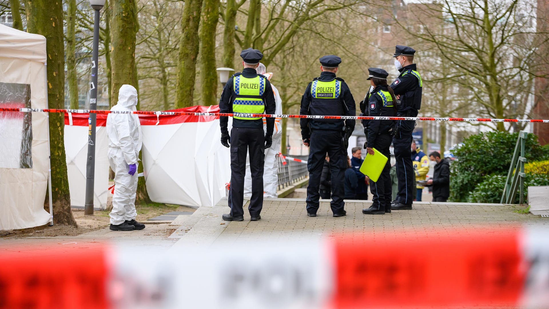Ermittler und Polizisten stehen an dem mit Flatterband und einem weißen Zelt abgesperrten Tatort (Archivbild): Die Staatsanwaltschaft hat nun den Mord-Verdacht bestätigt. Ermittler und Polizisten stehen an dem mit Flatterband und einem weißen Zelt abgesperrten Tatort (Archivbild): Die Staatsanwaltschaft hat nun den Mord-Verdacht bestätigt.
