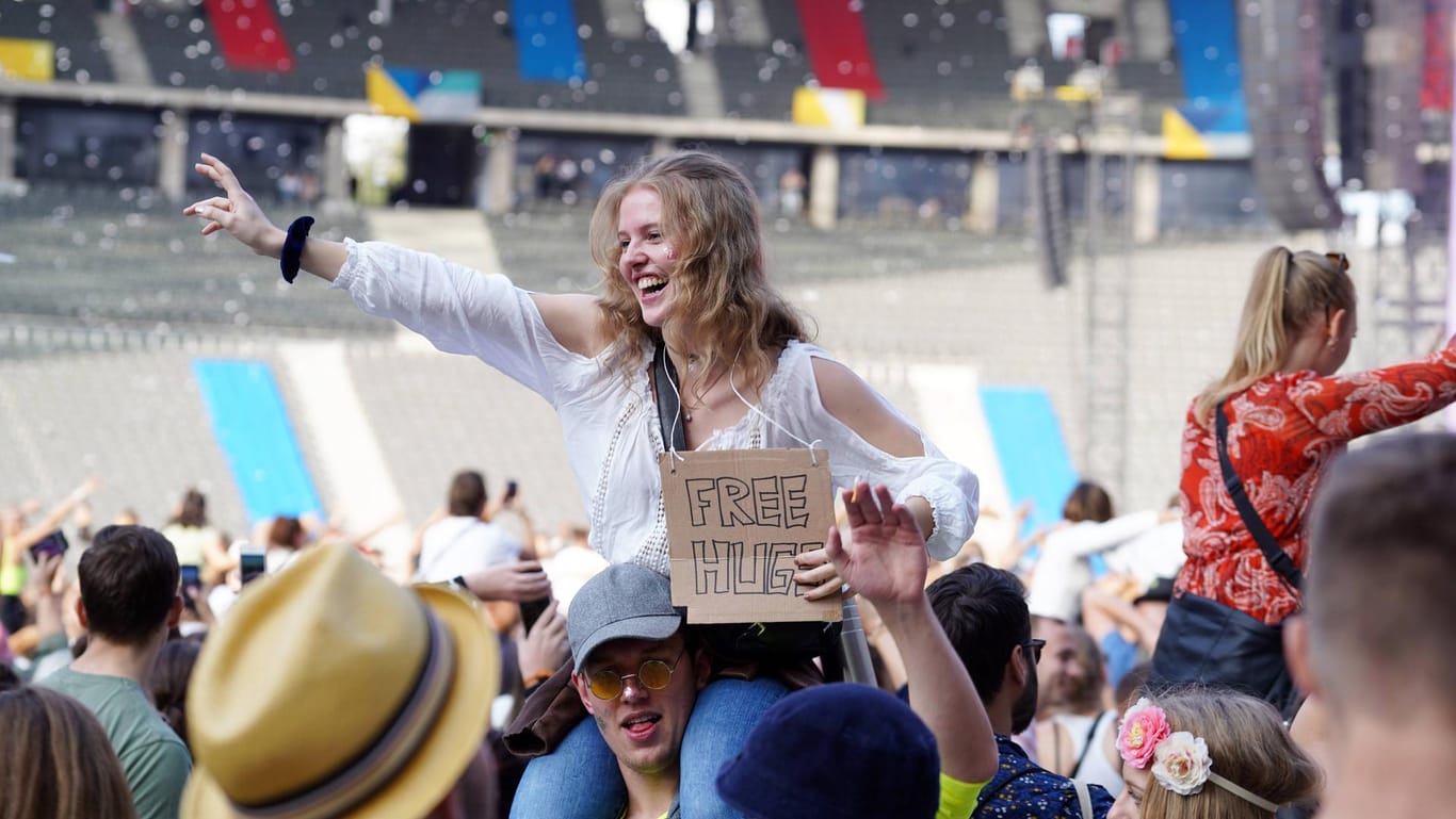 Feiernde mit einem "Free Hugs"-Schild für kostenlose Umarmungen beim Lollapalooza in Berlin 2019 (Archivbild): Tickets wird es dieses Jahr nur personalisiert geben.