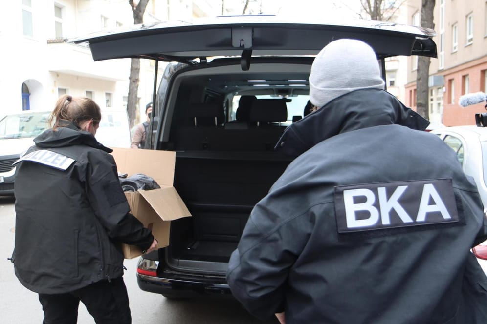Beamte räumen beschlagnahmte Beweismittel in ein Fahrzeug: Schwerpunkt der bundesweiten Razzia war Berlin.
