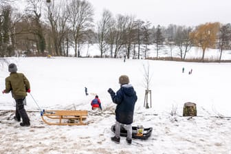 Kinder fahren Schlitten im Schnee (Symbolbild): Am kommenden Wochenende gibt es in Sachsen bis zu zehn Zentimeter Neuschnee.