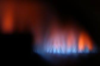 Eine Gasflamme brennt hinter dem Sichtfenster eines Gas-Durchlauferhitzers.