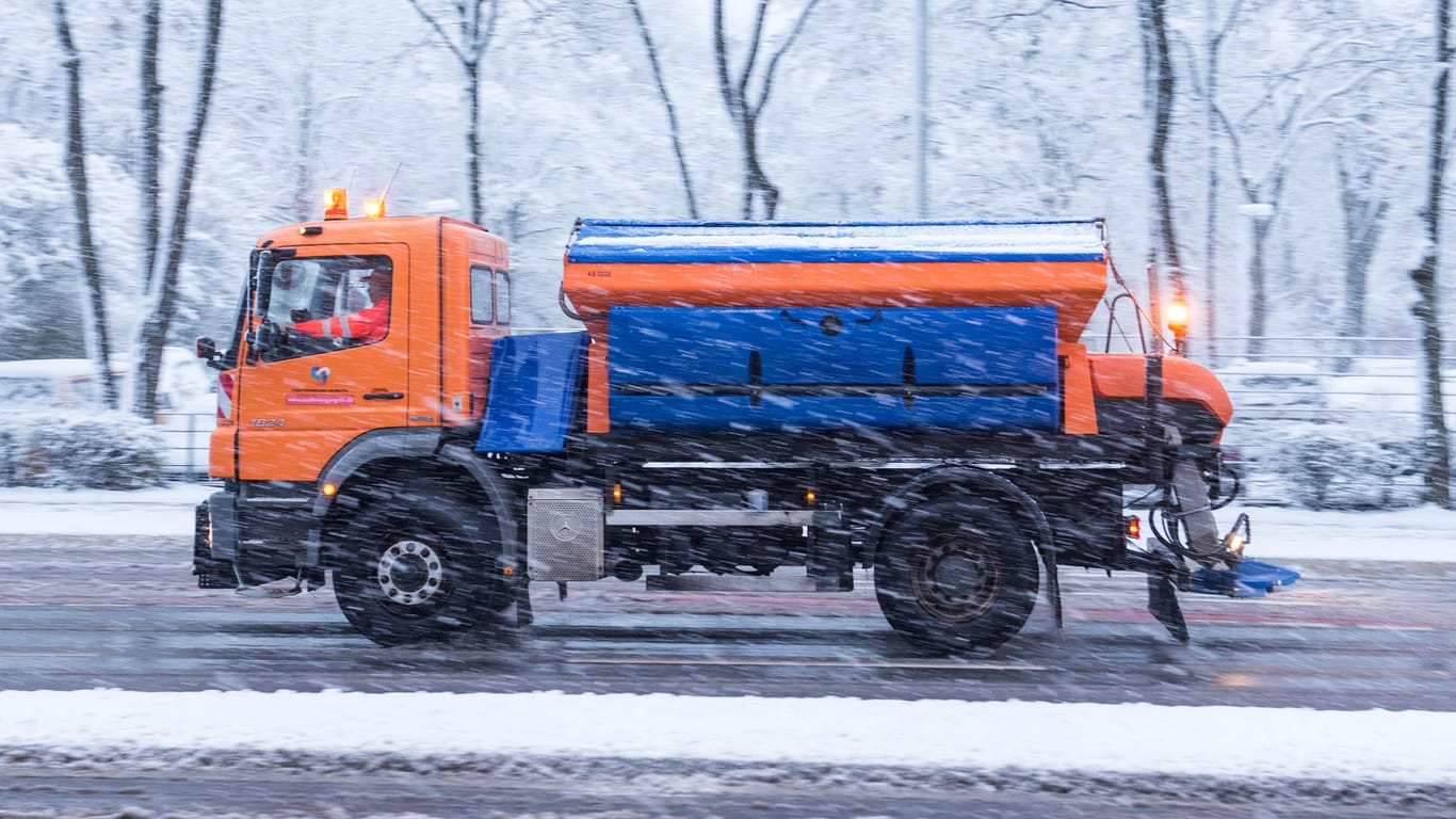 Ein Räumfahrzeug vom Winterdienst fährt bei Schneefall auf einer Straße. Bis Mitte April sind die Wagen in Rufbereitschaft.