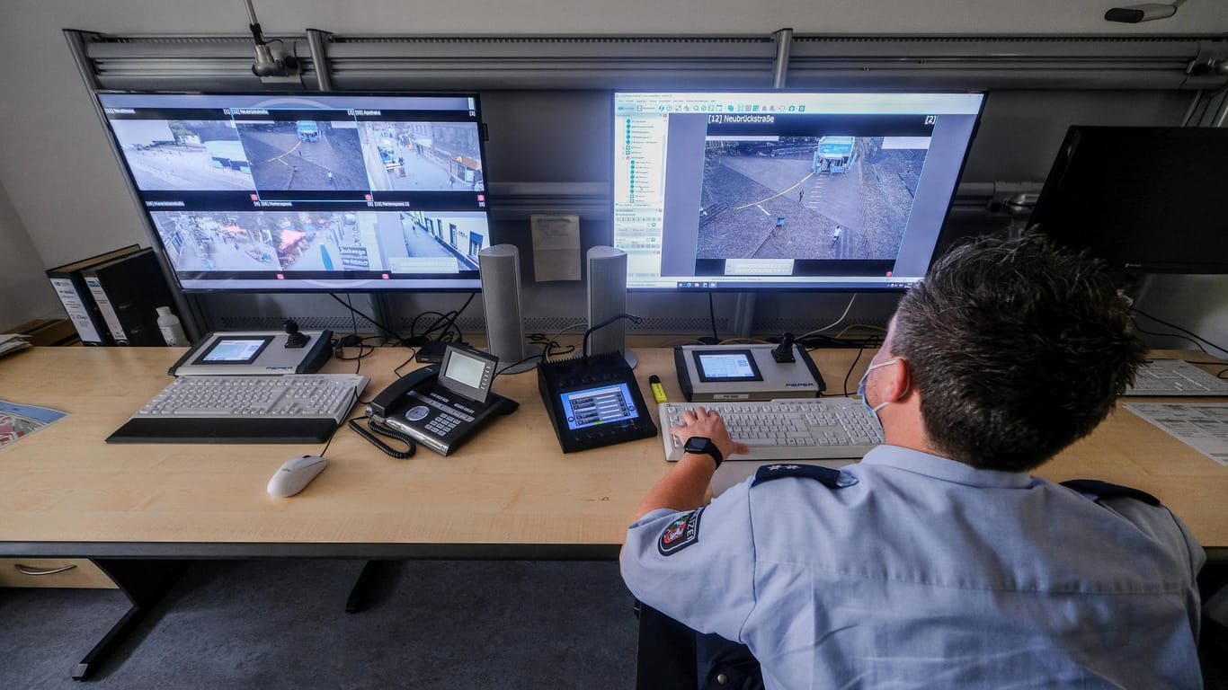 Ein Polizeibeamter bei der Observation an mehreren Monitoren (Archivbild): Der Berliner Senat hält die Anzahl der zu Oberservationszwecken von der Polizei gemieteten Räumlichkeiten geheim.