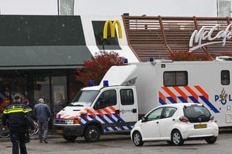 Polizisten ermittelt am Tatort, wo zwei Männer nach Schüssen in einem Schnellrestaurant ums Leben gekommen sind.
