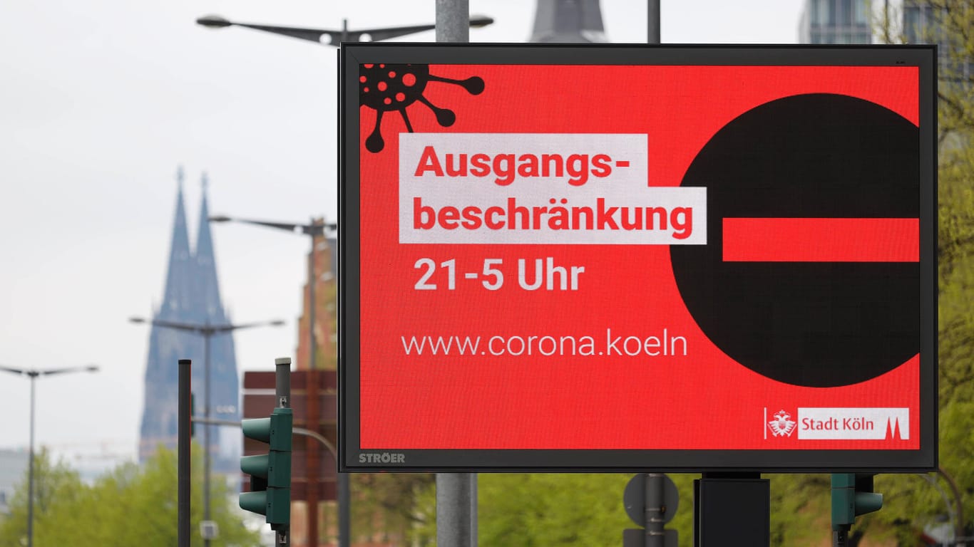 Eine Werbetafel weist Ende April 2021 auf die nächtlichen Ausgangsbeschränkungen als Teil der Corona-Maßnahmen in Köln hin (Archivbild): Auch hier kontrollierte das Ordnungsamt.