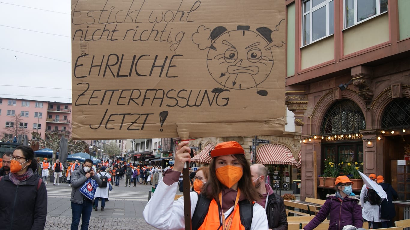 Demonstrantin mit Schild: Auch Darya streikt am Frankfurter für bessere Arbeitsbedingungen.