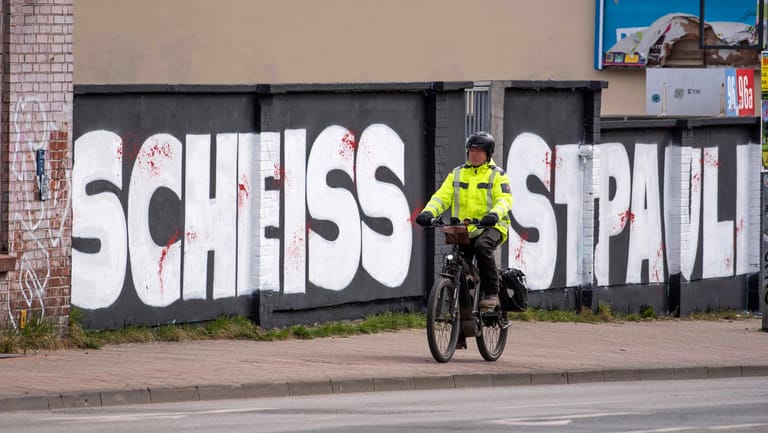 Ein Radfahrer fährt vor einem Graffiti auf dem Gehweg: Das Nordduell zwischen dem FC Hansa Rostock und dem FC St. Pauli ist als Risikospiel eingestuft. Die Fans der Zweitligisten verbindet eine traditionelle Rivalität.