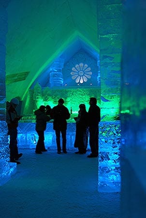 Ein besonders cooler Ort für einen Drink: Zum Eishotel in Québec gehört auch eine Lounge mit Bar und bunten Lichteffekten.