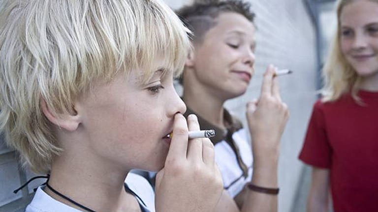 Zwei rauchende Jungs und ein Mädchen.