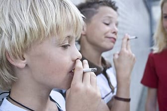Zwei rauchende Jungs und ein Mädchen.