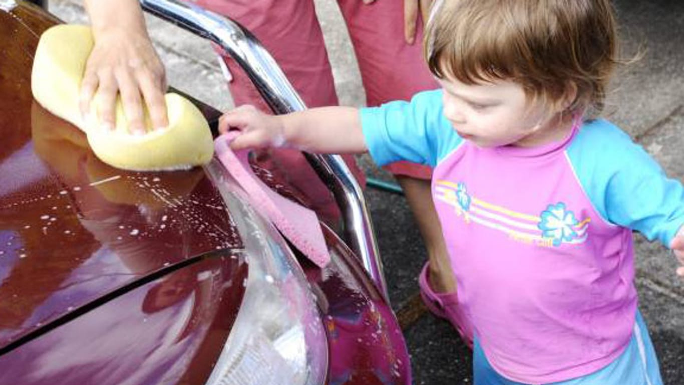Kleines Mädchen hilft beim Autowaschen.