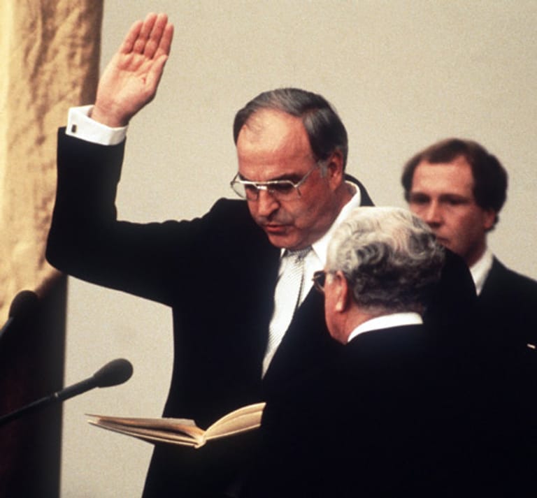 Mit der Vereidigung durch Bundestagspräsident Richard Stücklen (vorn) am 1.Oktober 1982 beginnt Kohls Rekord-Amtszeit.
