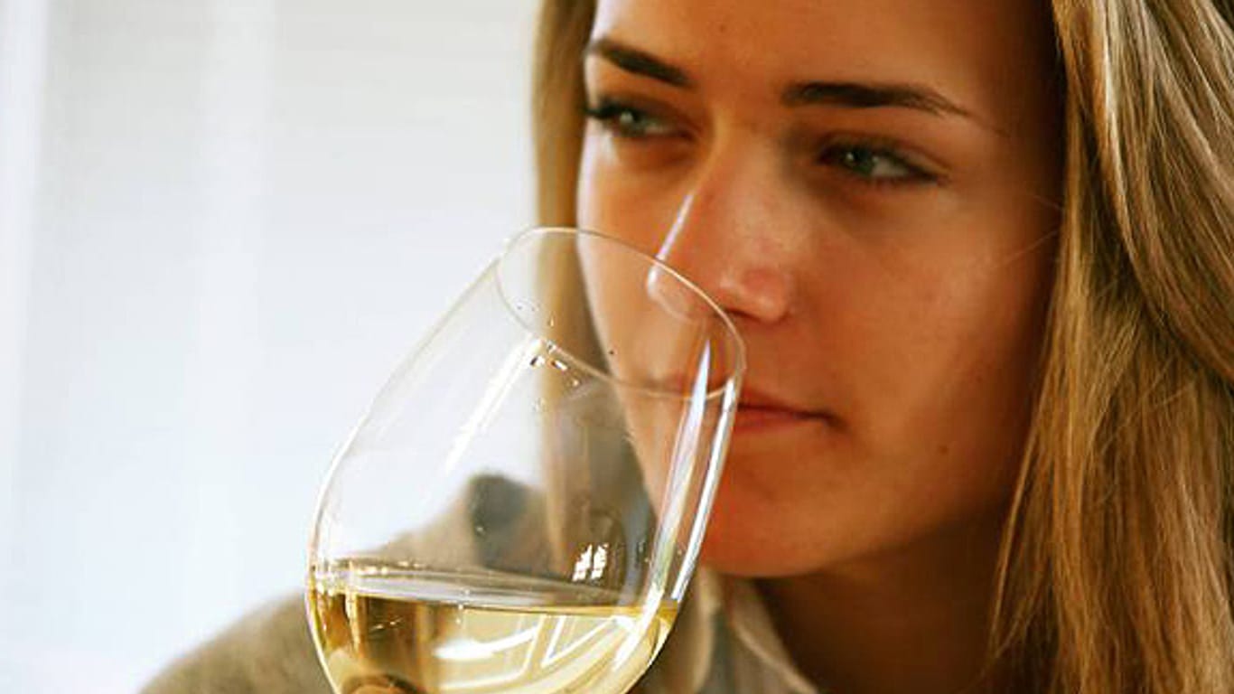 Frau trinkt ein Glas Weißwein.