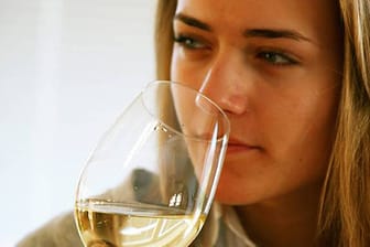 Frau trinkt ein Glas Weißwein.
