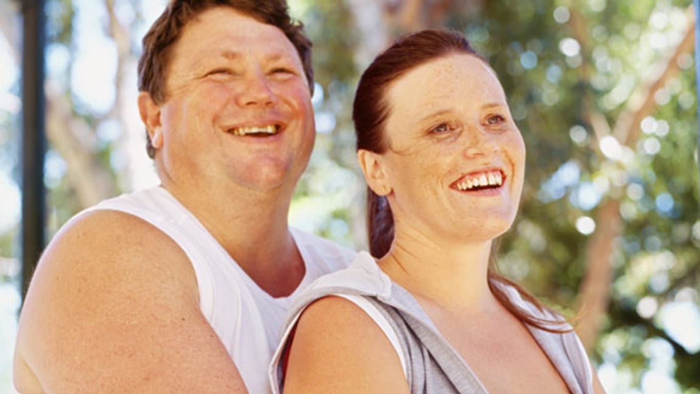 Übergewichtiger Mann umarmt seine Frau.