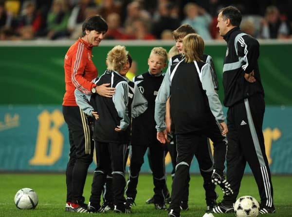 Bundestrainer Joachim Löw und Fußballkinder.