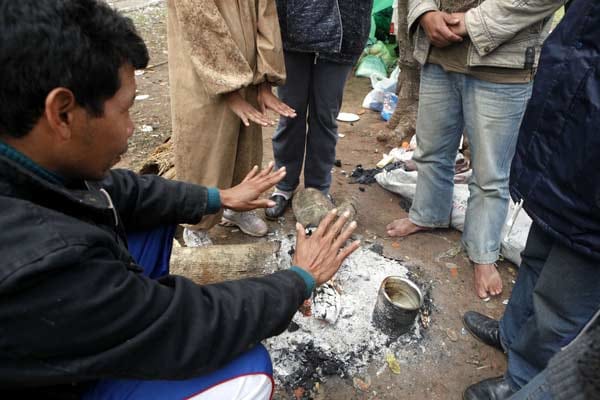 Bei bitterkalten Temperaturen in Paraguay wärmen sich diese Menschen an einem kleinen Feuer. Bei bitterkalten Temperaturen in Paraguay wärmen sich diese Menschen an einem kleinen Feuer.