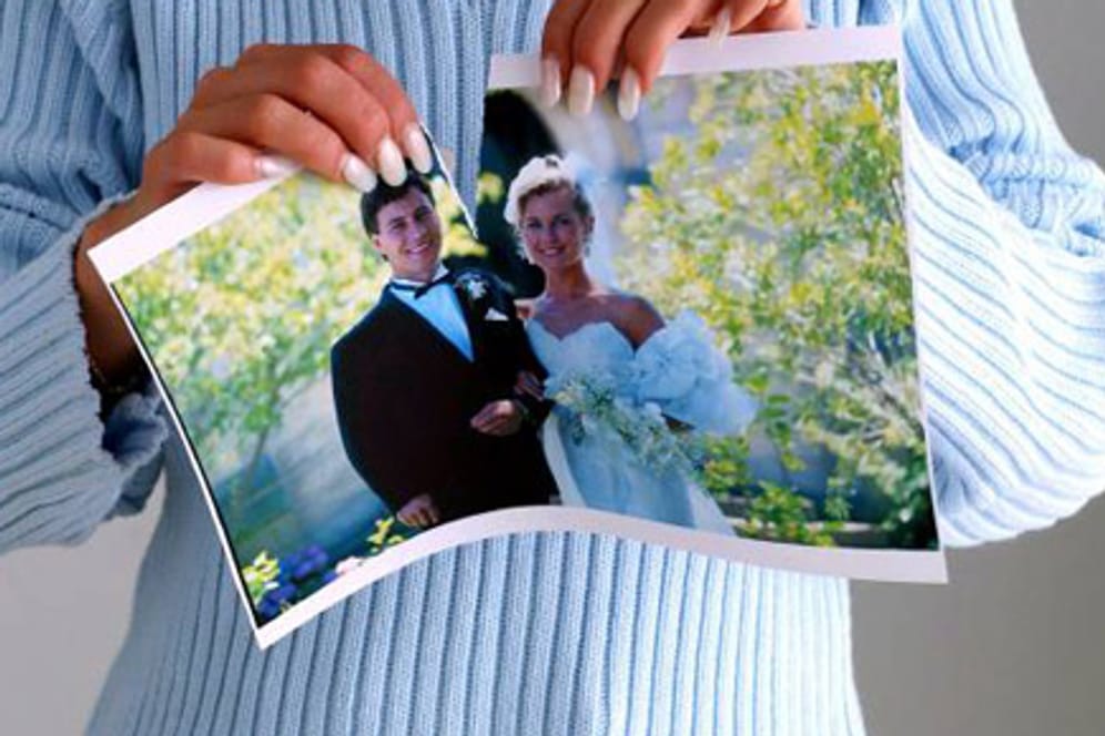 Frau zerreißt ihr Hochzeitsfoto.