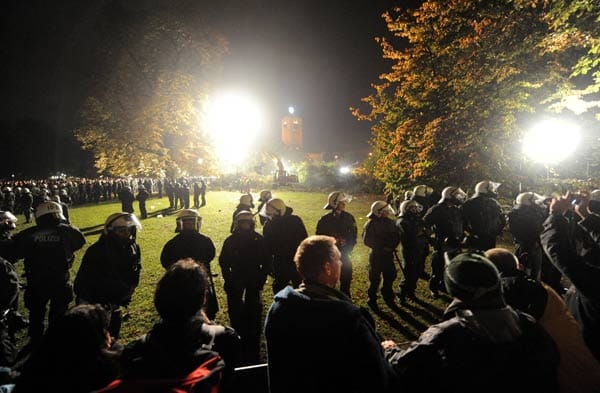 Rund 1000 Polizisten sperren den Schlossgarten ab, Demonstranten stehen ihnen gegenüber und begleiten die Arbeiten mit Pfiffen und Sprechchören.
