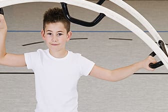 Sport: Junge trainiert mit einem Rhönrad.