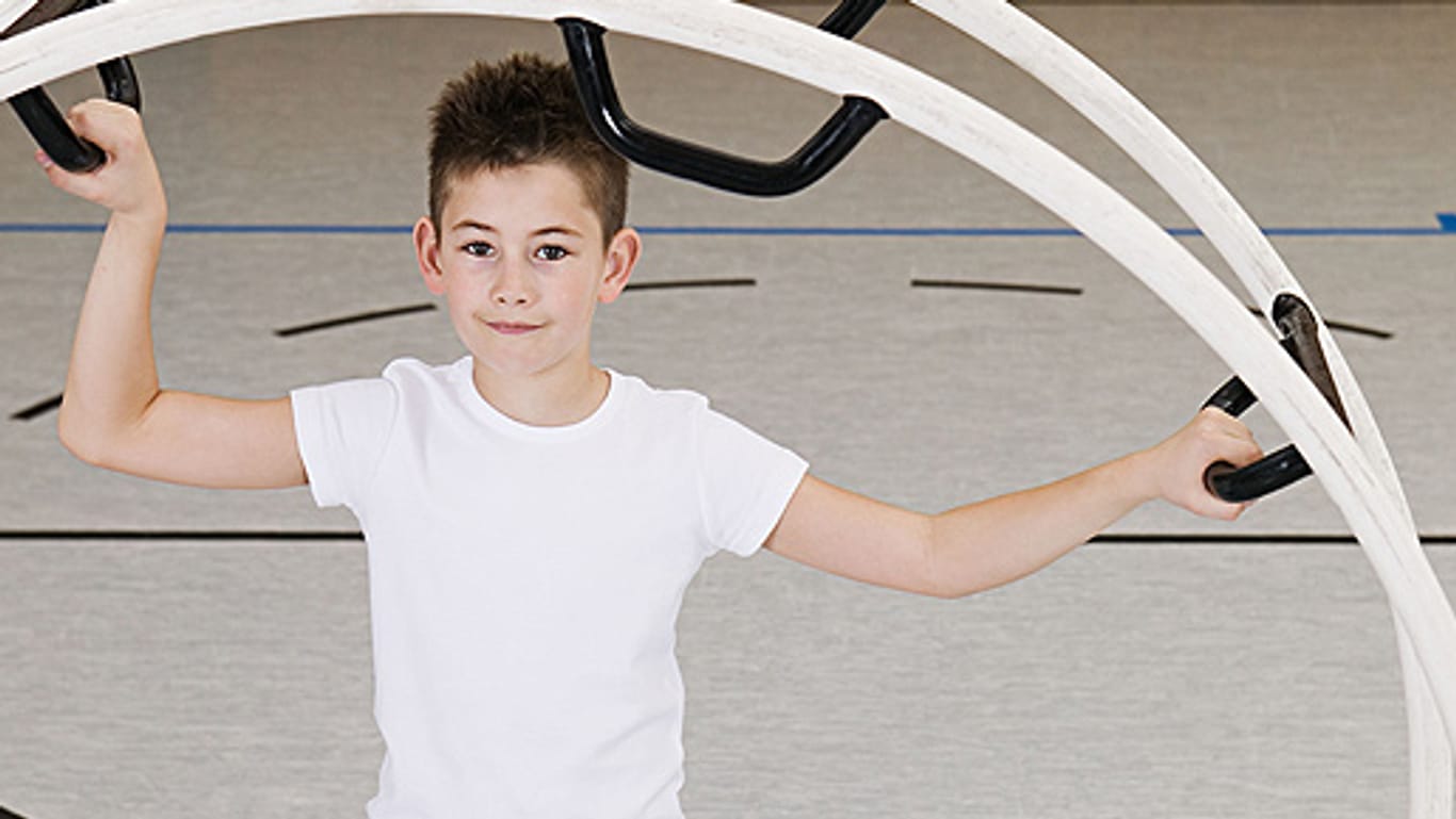 Sport: Junge trainiert mit einem Rhönrad.