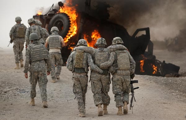 US-Soldaten stützen einen Kameraden, der bei einem Angriff verletzt worden ist.