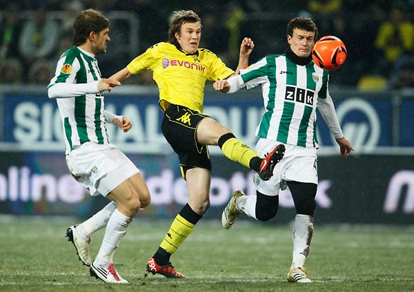 Karpaty Lwiws Nemanja Tubic (li.) und Artem Fedetskiy (re.) nehmen Dortmunds Kevin Grosskreutz (Mi.) in die Mangel.