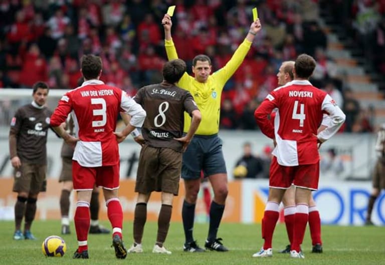 Wie ein Cowboy im Wilden Westen: Thomas Metzen zeigt Paulis Florian Bruns und Miroslav Karhan vom FSV Mainz 05 die doppelte Gelbe Karte.