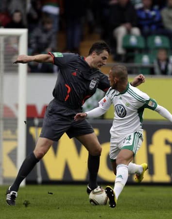 Knut Kircher tanzt mit Wolfsburgs Ashkan Dejagah um den Ball.