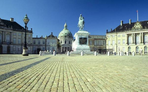 Das Schloss Amalienborg ist die Kopenhagener Stadtresidenz der dänischen Königin Margrethe II. Ist sie anwesend, wird eine Flagge gehisst und an diesen Tagen findet um 12 Uhr die Wachablösung der Garden vor dem Schloss statt.