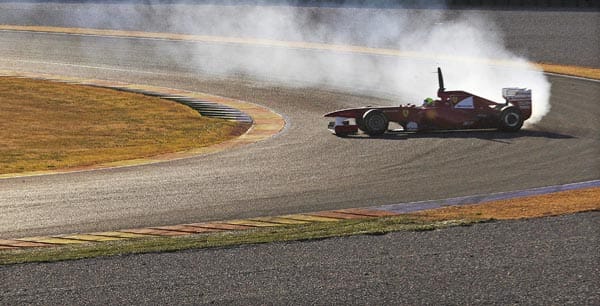 Felipe Massa fegt mit seinem Ferrari um die Kurve, aus dem Motor schlagen erste Rauchfahnen...