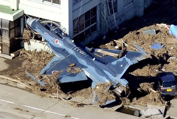 Ein Kampfflugzeug wurde von dem Tsunami gegen ein Gebäude auf dem Flugplatz in Matsushima gedrückt.