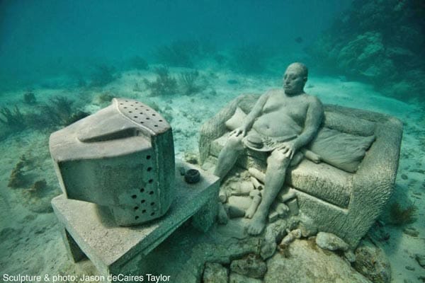 Burger und Pommes auf dem Schoß, Bierbauch raus und Blick auf die Glotze: Auch diese Skulptur gehört zu dem Unterwassermuseums Mexikos.