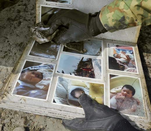 Ein Soldat säubert in der Stadt Minami Sanriku in der Präfektur Miyagi im Nordosten von Japan ein Fotoalbum, das er in den Trümmern der Stadt gefunden hat.