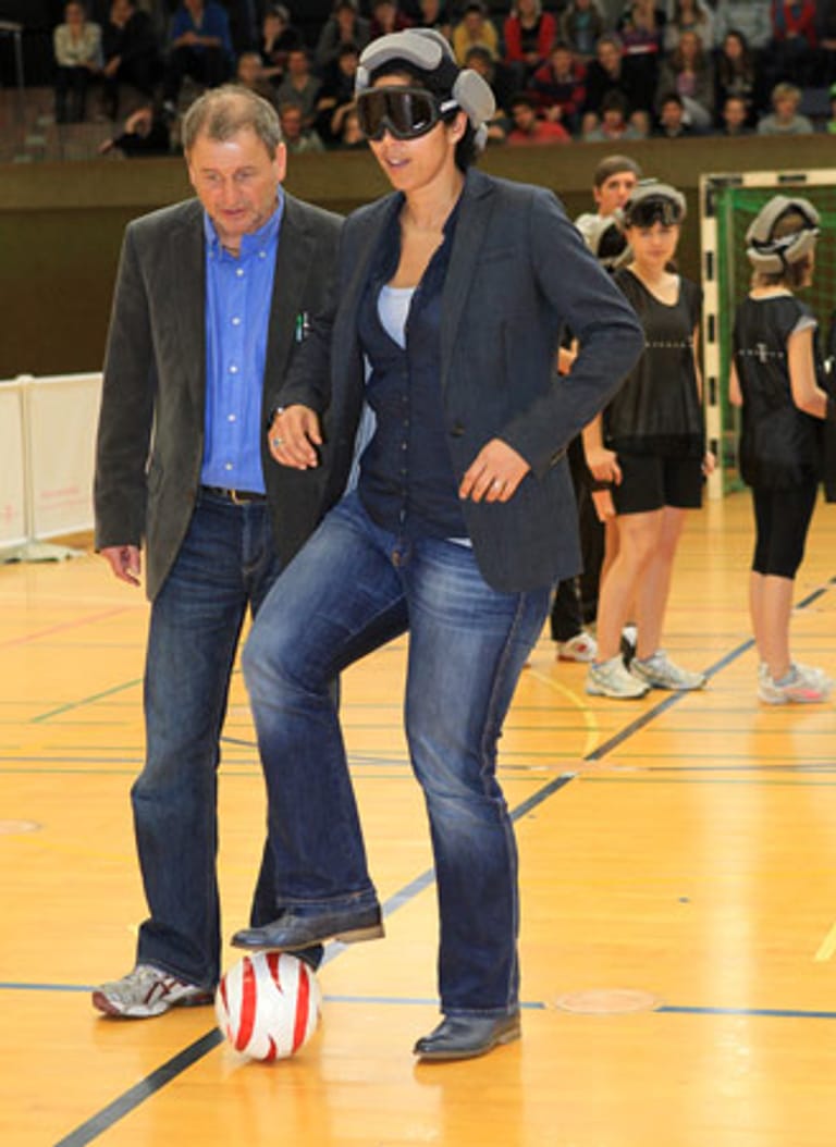 Steffi Jones (r.), OK-Chefin der FIFA Frauen-WM 2011, wird bei ihren ersten Schritten von Blindenfußball-Nationaltrainer Ulrich Pfisterer (l.) unterstützt.