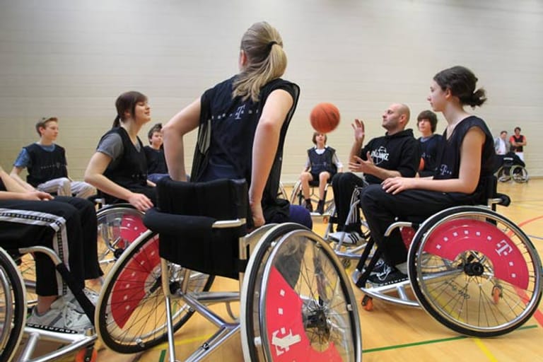 Rollstuhl-Basketball-Nationalspieler Uli Schmölz (2. v.r.) übt mit Schülern den richtigen Umgang mit Rollstuhl und Ball.