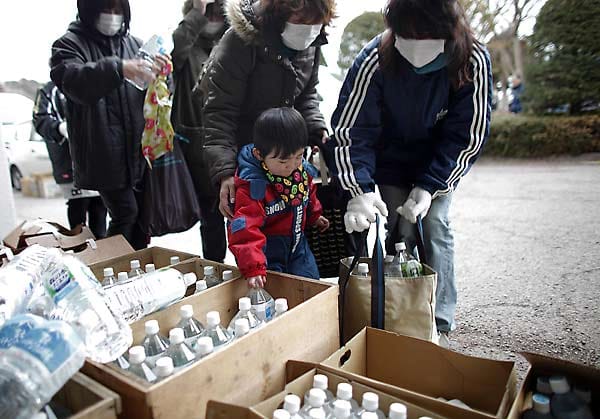 Familien in Yamada versorgen sich mit Trinkwasser aus Flaschen. Auch im Norden der japanischen Hauptinsel sorgen sich die Menschen am 24. März 2011 vor einer radioaktiven Verseuchung ihres Wassers.