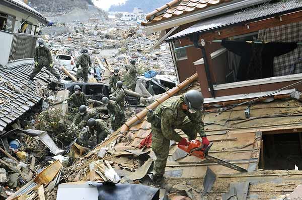 Soldaten der japanischen Selbstverteidigungsstreitkräfte suchen am 25. März 2011 mit bloßen Händen und einer Motorsäge nach Opfern des Tsunami in Onagawa.