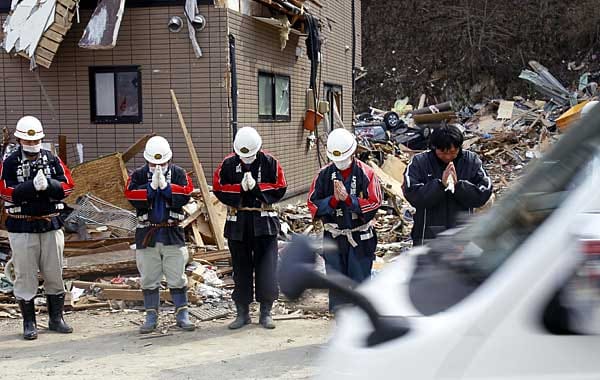 Feuerwehrleute halten während der Suche nach Opfern des verheerenden Erdbebens kurz für ein Gebet inne.