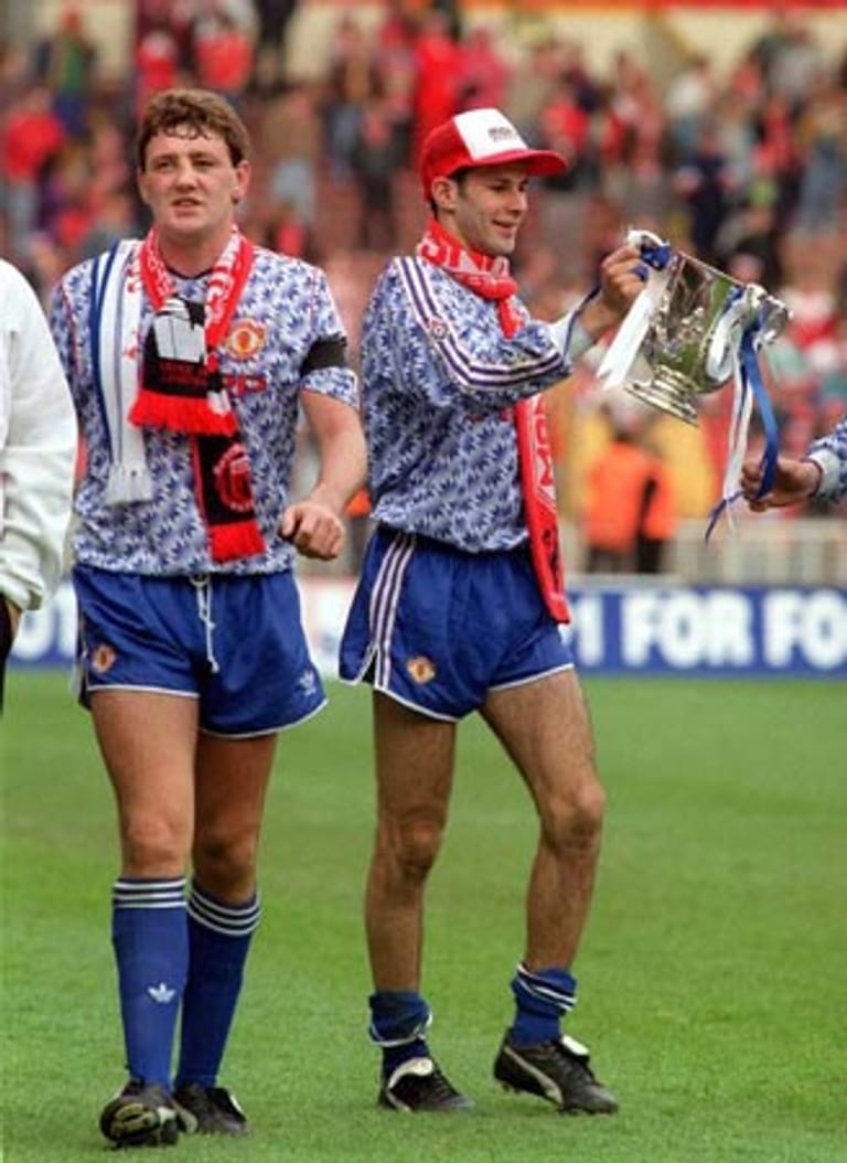 Besonders in Schale warfen sich Steve Bruce (l.) und Ryan Giggs anlässlich des Ligapokal-Siegs ihres Klubs Manchester United im Jahr 1992. Manchen dürfte das Muster ihrer Trikots aber eher aus der Porzellan-Sammlung der Großeltern geläufig sein.