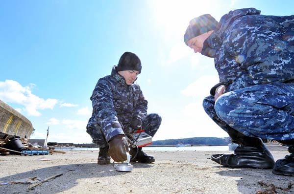 Soldaten der US-Navy messen in Kesenuma die Strahlenbelastung des Bodens.