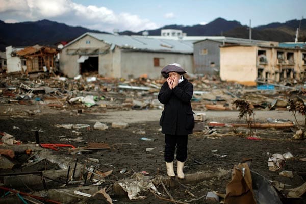 Nach dem verheerenden Tsunami in Japan steht eine Frau in Kessenuma entsetzt vor den Resten ihres zerstörten Hauses.