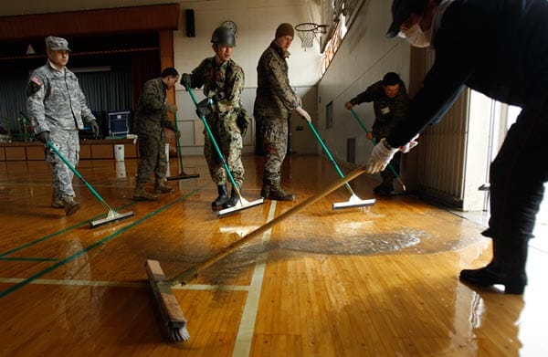 Japanische Helfer säubern mit Hilfe von US-Militär eine Oberschule in Ishinomaki.