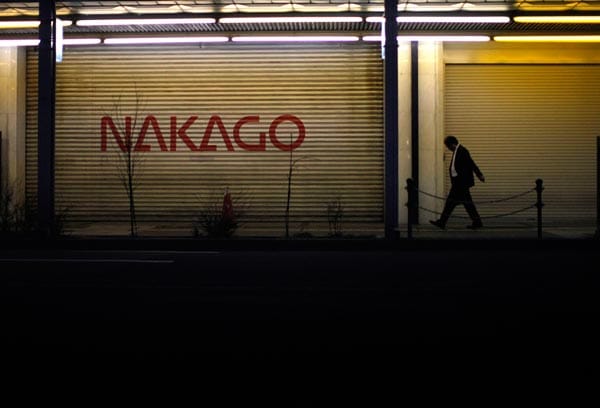 Ein Mann läuft in der Innenstadt von Fukushima entlang eines geschlossenen Geschäfts.